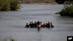 FILE - Migrants, mostly from Nicaragua, cross the Rio Grande into the U.S., at Eagle Pass, Texas, May 20, 2022. 