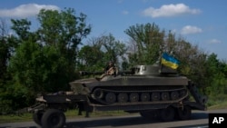 A tank is towed near Slovyansk, eastern Ukraine, June 4, 2022.