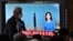 A man walks past a screen showing a news broadcast with file footage of a North Korean missile test, at a railway station in Seoul on June 5, 2022.