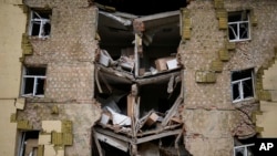 Debris hangs from a residential building heavily damaged in a Russian bombing in Bakhmut, eastern Ukraine, eastern Ukraine, May 28, 2022.