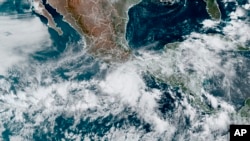 This satellite image made available by NOAA shows Hurricane Agatha, center, off the Pacific coast of Mexico on May 29, 2022, at 11:20 a.m. EDT. 