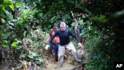 Jurnalis Inggris Dom Phillips, kanan, dan seorang pria Suku Yanomami berjalan di Desa Maloca Papiu, negara bagian Roraima, Brazil, November 2019. (Foto: AP)