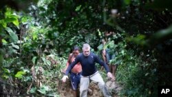 ARCHIVO - El periodista británico Dom Phillips, a la cabeza, y un indígena Yanomami caminan por las proximidades del poblado de Maloca Papiu village, en el estado de Roraima, Brasil, en noviembre de 2019. 