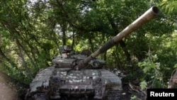 A Ukrainian serviceman sits inside a tank at a position in Donetsk region, Ukraine, June 11, 2022. 