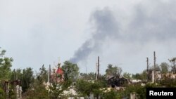 El humo se eleva sobre una iglesia y edificios residenciales en el curso del conflicto entre Ucrania y Rusia en la ciudad de Rubizhne en la región de Lugansk, Ucrania, el 1 de junio de 2022.