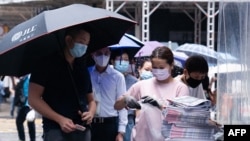 FILE - A man purchases a copy of the Apple Daily newspaper's final edition in Hong Kong's Central district on June 24, 2021, after the pro-democracy tabloid was forced to close after 26 years under a sweeping new national security law. 