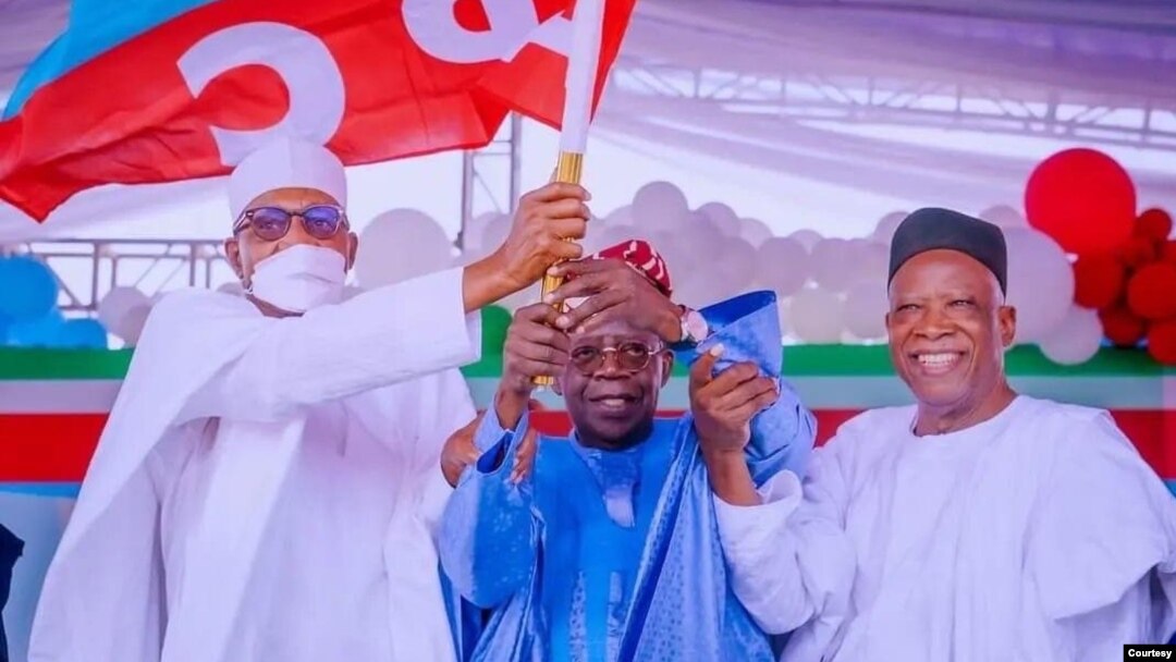 Lokacin da shugaba Buhari ya ba Tinubu (tsakiya) tutar jam'iyya (Hoto: Fadar shugaban kasa).