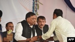 Bangladeshi pirates lay down their weapons to Bangladesh Home Minister Asaduzzaman Khan, center, as they surrender, in Cox's Bazar on Nov. 23, 2019.