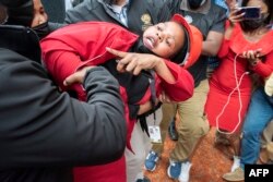 Un député du parti d'opposition Economic Freedom Fighters est traîné hors du parlement par des agents de sécurité, après avoir tenté de perturber un discours du président sud-africain Cyril Ramaphosa, au Cap, le 9 juin 2022.