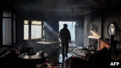 A firefighter inspects damage at a partially burned house in Panorama Voulas, south of Athens, June 4, 2022.