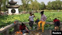 People and children enjoy themselves by the lakeside at a park during the Dragon Boat festival holiday, following the COVID-19 outbreak in Beijing, China, June 4, 2022.