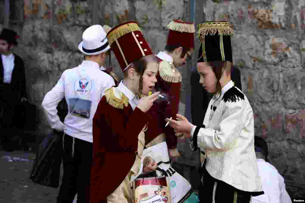Ultra-Orthodox Jewish children smoke during celebrations marking the Jewish holiday of Purim in Jerusalem&#39;s Mea Shearim neighborhood, Israel.