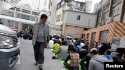 一名中國男子看著上海一座清真寺的維吾爾穆斯林祈禱。(2014年4月11日)