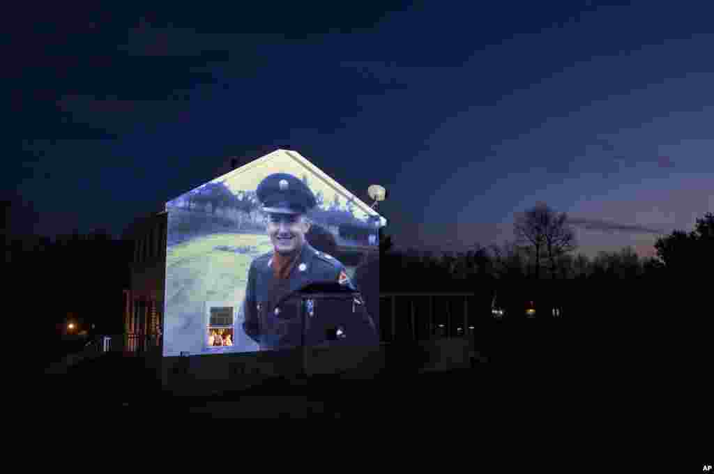 Изображение ветерана армии США Честера ЛаПланте проецируется на дом его сына Рэнди в Амстердаме, штат Нью-Йорк. ЛаПланте умер от COVID-19 в возрасте 78 лет (фото: AP/David Goldman)