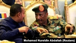 Le chef du Conseil militaire de transition du Soudan, le lieutenant-général Abdel Fattah Al-Burhan, avec le Premier ministre éthiopien Abiy Ahmed lors de la signature de l'accord de partage du pouvoir, à Khartoum, Soudan, le 17 août 2019. REUTERS / Mohamed Nureldin Abdallah