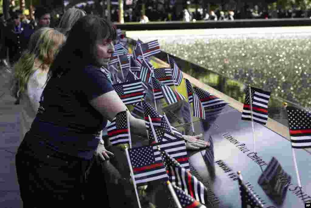 Family members place flowers on the south pool during the 9/11 Memorial ceremony on the 23rd anniversary of the Sept. 11, 2001 attacks, in New York.&nbsp;