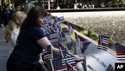 Family members place flowers on the south pool during the 9/11 Memorial ceremony on the 23rd anniversary of the Sept. 11, 2001 attacks, in New York.&nbsp;