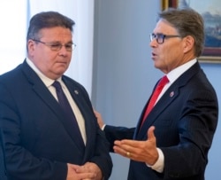 FILE - U.S. Energy Secretary Rick Perry, right, speaks to Lithuania's Foreign Minister Linas Linkevicius at the presidential palace in Vilnius, Lithuania, Oct. 7, 2019.