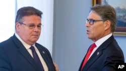 FILE - U.S. Energy Secretary Rick Perry, right, speaks to the Lithuania's Foreign Minister Linas Linkevicius at the Presidential palace in Vilnius, Lithuania, Oct. 7, 2019. 