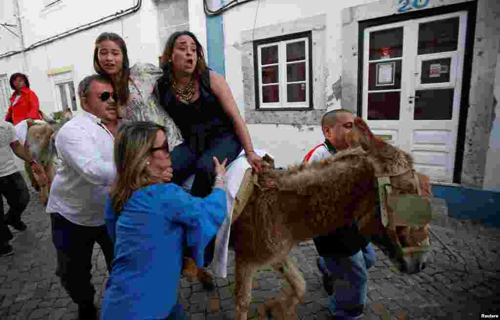 포루투갈 리즈본 인근 알쿠셋 시에서 부활 주간 행사 &#39;비그렘 다 아탈라이&#39; 행진에 참가한 여성들이 당나귀를 타고 있다.