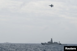 Pesawat tempur F-16 milik TNI AU terbang melintas di atas kapal perang TNI AL dalam operasi di Natuna, di dekat Laut China Selatan, Indonesia, 10 Januari 2020. (Foto: Risyal Hidayat/Antara via Reuters)