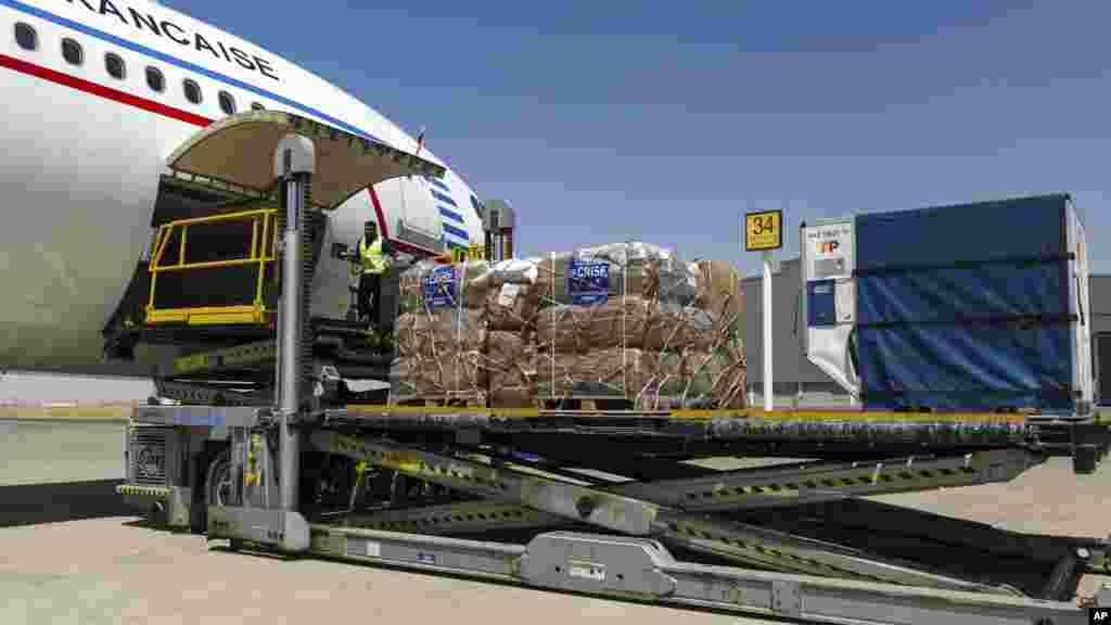 In this photo provided Aug. 11 by the French Army, airport employees unload humanitarian freight from a French Air Force plane at Irbil airport in Iraqi Kurdistan, Aug. 10. 2014.