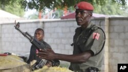 Polisi Nigeria berjaga di sepanjang bunker di jalanan Maiduguri, Nigeria (Foto: dok). Sekelompok bersenjata meledakkan bom di dekat sebuah sekolah Islam di Nigeria Utara, Minggu (30/9).