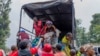 Orang-orang yang menyeberang dari Kongo ke Rwanda turun dari truk setibanya di kota Gyseny, Rwanda, Selasa, 28 Januari 2025. (Foto: Yuhi Irakiza/AP Photo)