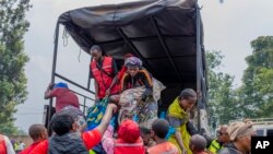 Orang-orang yang menyeberang dari Kongo ke Rwanda turun dari truk setibanya di kota Gyseny, Rwanda, Selasa, 28 Januari 2025. (Foto: Yuhi Irakiza/AP Photo)