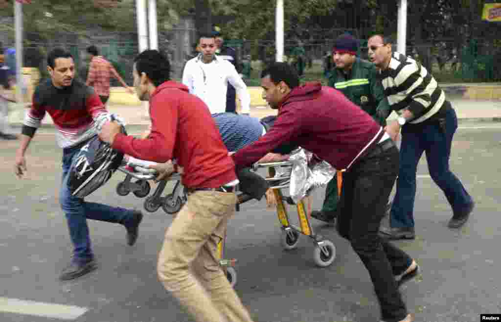 People use a stretcher to transport the body of a police officer who was killed in explosions near Cairo University, April 2, 2014. 