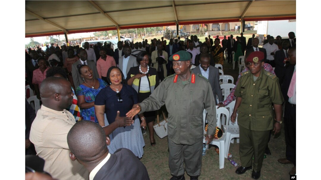 FILE - Uganda President Yoweri Museveni, center in military uniform, greets relatives of prison wardens during a graduation ceremony in the capital Kampala Thursday Jan. 18, 2018.