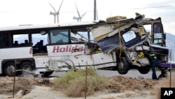 Para pekerja berusaha mengangkut bus wisata yang ringsek setelah kecelakaan di Desert Hot Springs, California, Minggu pagi (23/10).