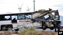 Workers prepare to haul away a tour bus that crashed with semi-truck on Interstate 10 just west of the Indian Canyon Drive off-ramp, in Desert Hot Springs, near Palm Springs, California, Oct. 23, 2016.