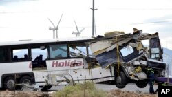在撞车地点加州棕榈泉附近，工人们准备把巴士拖走（2016年10月23日）