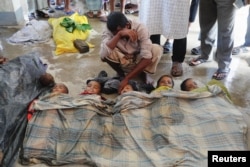 FILE - Shuna Miya cries over bodies of his daughters, before their bodies are taken for the funeral just behind Inani Beach near Cox's Bazar, Bangladesh, Sept. 29, 2017.