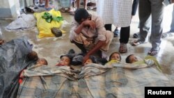 Shuna Miya cries over bodies of his daughters, before their bodies are taken for the funeral just behind Inani Beach near Cox's Bazar, Bangladesh, Sept. 29, 2017. 