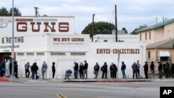 FILE - People wait in a line to enter a gun store in Culver City, Calif., March 15, 2020. 