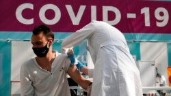 FILE - In this July 12, 2021, photo, a medical worker administers a shot of Russia's Sputnik V coronavirus vaccine at a vaccination center in Gostinny Dvor, a huge exhibition place in Moscow.