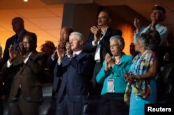 Former President Bill Clinton applauds first lady Michelle Obama's speech at the Democratic National Convention in Philadelphia, July 25, 2016.