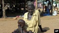 Sudanese man holds malnourished grandson at Medicine Sans Frontieres feeding center, Sept. 2005 (file photo).