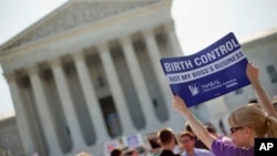 FILE - Demonstrator holding up a sign outside the Supreme Court in Washington, June 30, 2014. The Obama administration announced new measures Aug.22 to allow religious non-profits and some companies to opt out of paying for birth control for female employees whi
