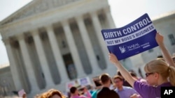 Demonstrator holding up a sign outside the Supreme Court in Washington, June 30, 2014. The Obama administration announced new measures Aug.22 to allow religious non-profits and some companies to opt out of paying for birth control for female employees whi