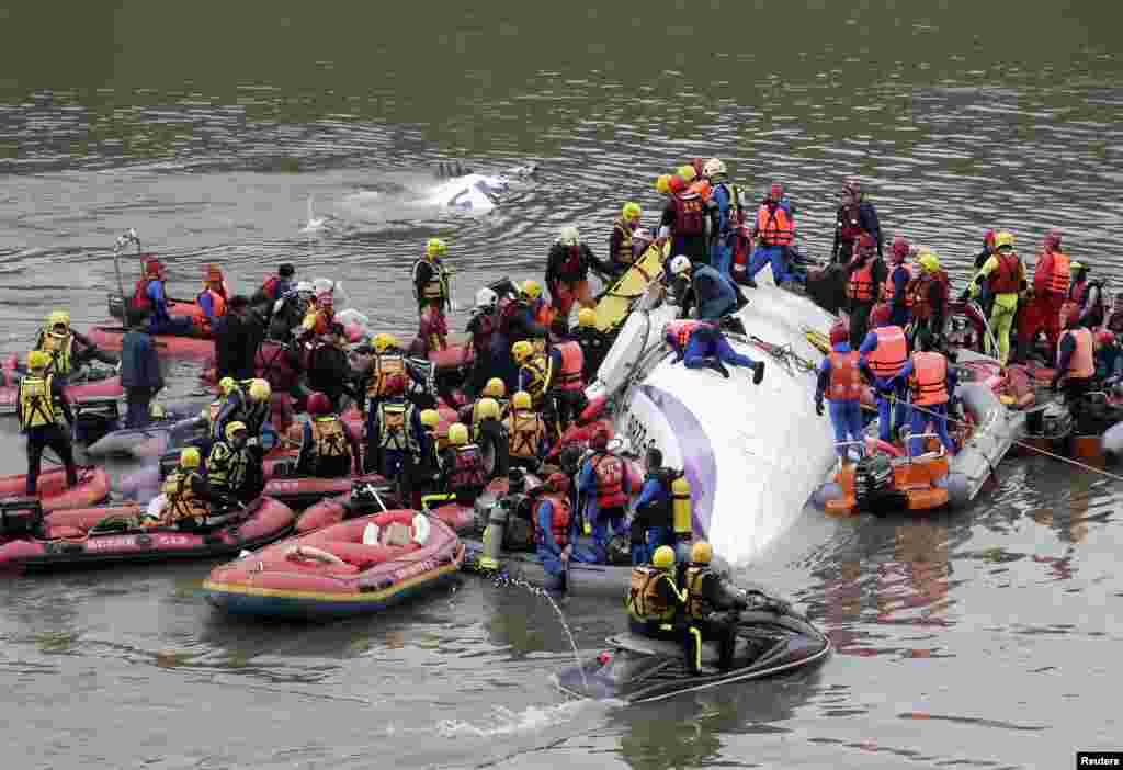 Rescuers carry out rescue operations after a TransAsia plane crashed into a river in New Taipei City.