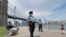 A youngster approaches a team of New York City police officers as they walk with face masks to hand out to anyone who needs or asks for one during the current coronavirus outbreak, Sunday, May 17, 2020, in Brooklyn Bridge Park in New York.