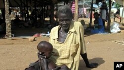 Amid famine in the Horn of African, World Food Program officials are now calling for increased food aid in Zimbabwe. Above, Man and malnourished grandson at food clinic in Sudan, Sept. 11 2005 (file photo).