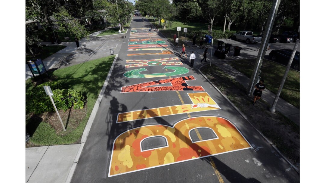 Several local artists painted Black Live Matter mural on the street during a Juneteenth 2020 celebration outside the Dr. Carter G. Woodson African American Museum Friday, June 19, 2020, in St. Petersburg, Fla.