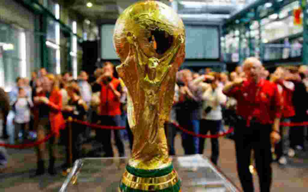 Los visitantes se amontonan cerca al trofeo del mundial de la FIFA que estaba en exhibición en Zúrich, Suiza, como parte de un tour.