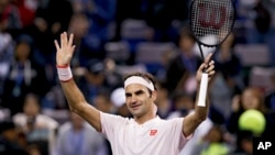 FILE - Roger Federer of Switzerland waves to spectators after prevailing in a singles match at Qizhong Forest Sports City Tennis Center in Shanghai, China, Oct. 10, 2018. 