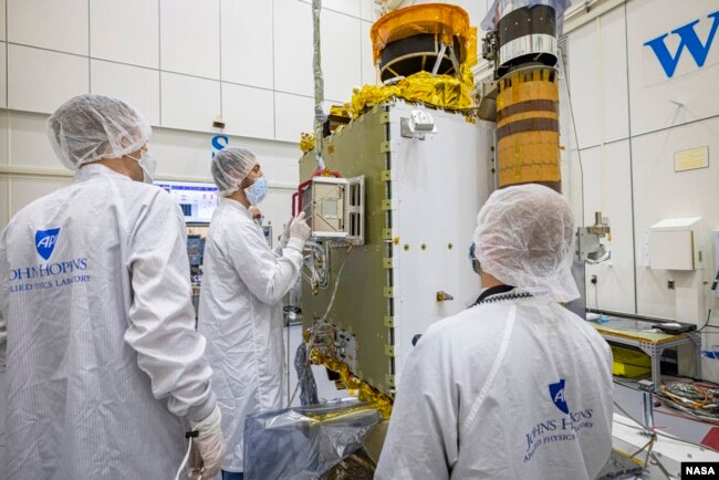 DART team members from the Johns Hopkins Applied Physics Laboratory in Maryland and the Italian Space Agency carefully position the LICIACube into place on the DART spacecraft. (Image Credits: NASA/Johns Hopkins APL/Ed Whitman)