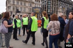 英国国会外站着一些穿着“撒玛利亚会”(Samaritans)绿色背心的义工，让伤心的民众可以倾诉 (美国之音/郑乐捷)